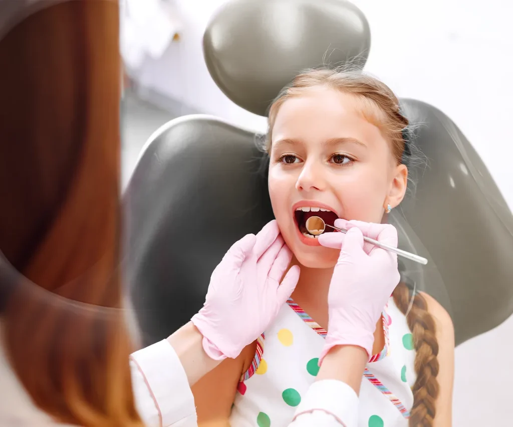 Pediatric dentist performing pulpectomy treatment for a child with cavities